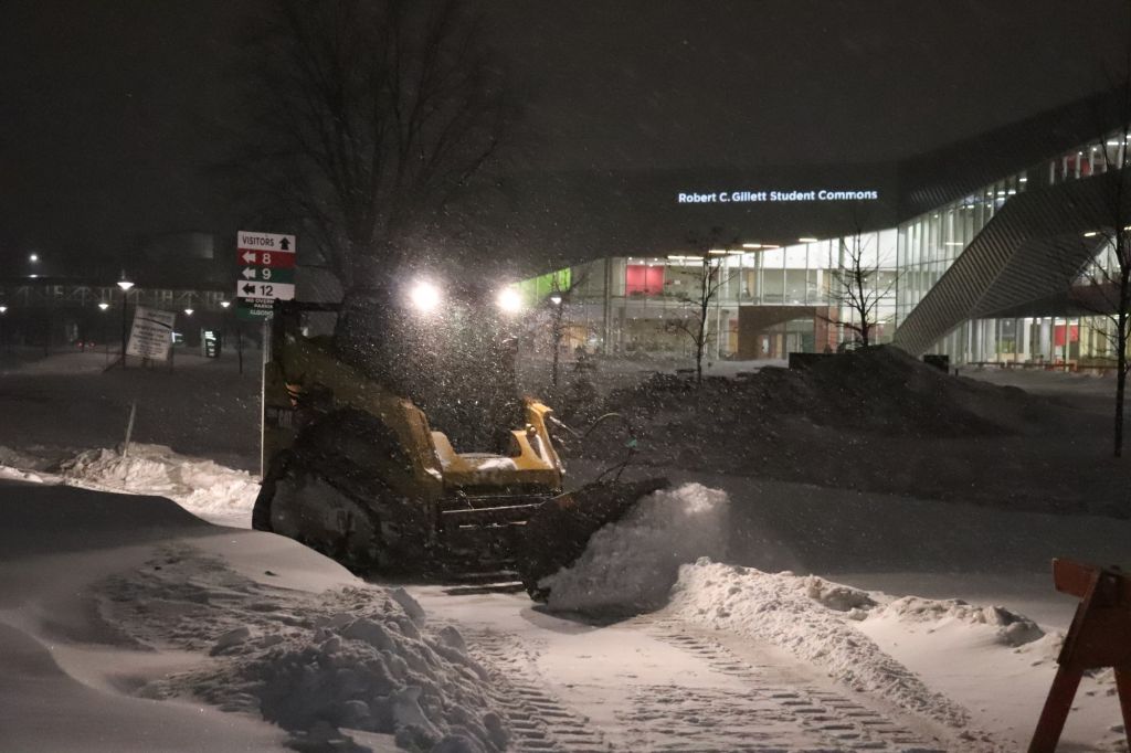 Crews clear snow behind Algonquin College the evening of Feb. 12. A severe storm warning has forced the school to close for most of Wednesday.