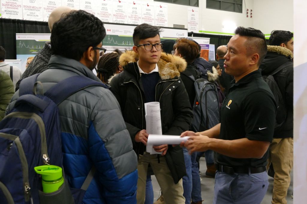 Patrick Chen, representing Versaterm at the college's annual Careers Fair, informs Peter Gani and other students about job opportunities. The Feb. 12 fair brought out hundreds of students to network with over 70 prospective employers.