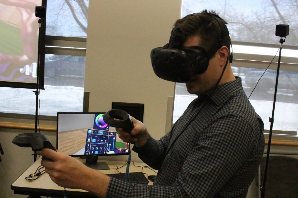 David Solomon with a Virtual Reality headset to demonstrate its use and how it works by creating an art piece for a faculty member at Algonquin.