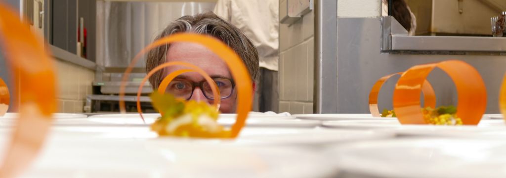 Award-winning chef Marc Lepine peers through some of the many Carrot Hoop dishes made by culinary management students. The hoop was one of six dishes that Lepine shared with the program.