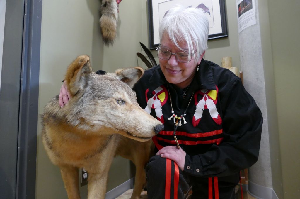 Raven Brightmoon smiles as she pets the stuffed wolf that stands in the Mamidosewin Centre. Brightmoon was the owner of the wolf for 20 years, and described it as her protector in times of hardship.