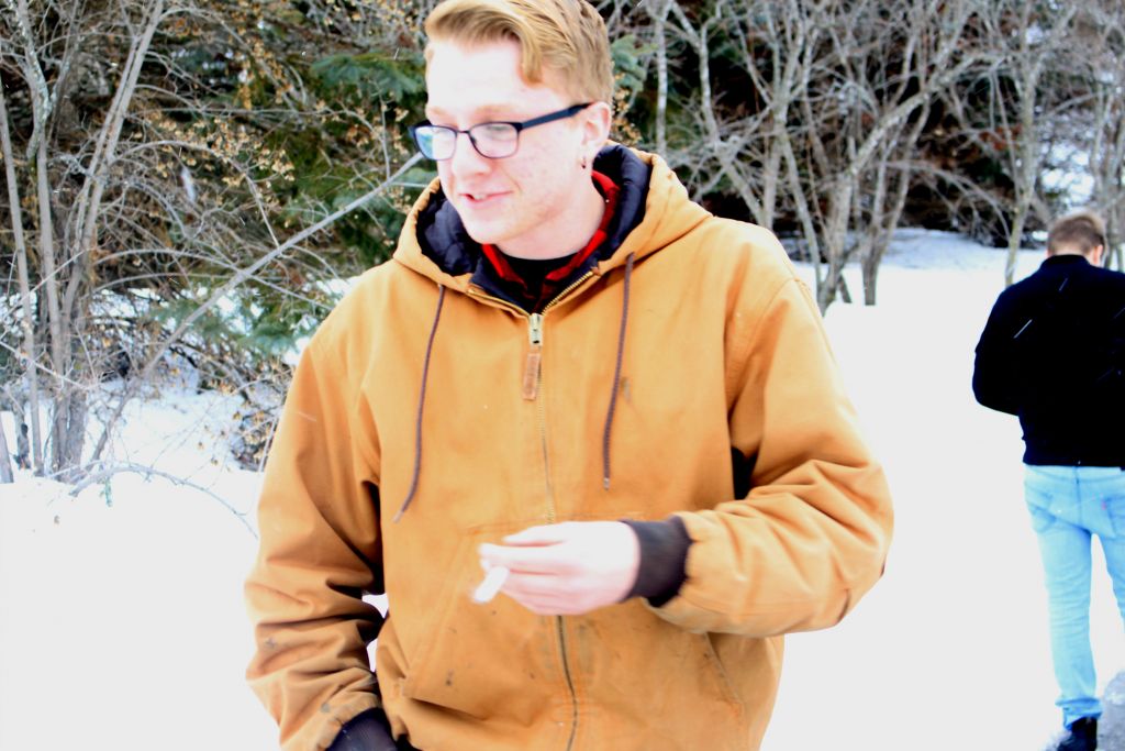 Nick Hubert, a mechanical engineering student, smoking just off campus on March 11. The entryway to the nearby park close to T-building has quickly become one of the fave spots for smokers.
