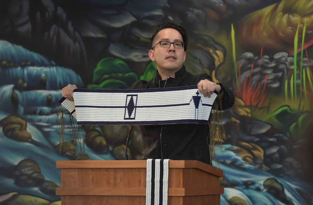 Ron Deganadus McLester,  Algonquin's vice president of truth, reconciliation and Indigenization, holds up Algonquin College's wampum belt at the Gather to Heal ceremony.