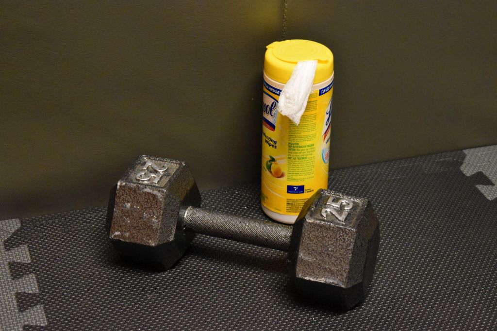 A pack of disinfecting wipes sits close to a dumbbell