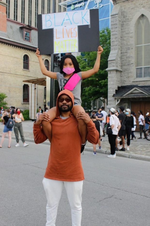 David Muipatayi and his daughter Najya hold a Black Lives Matter sign at the march