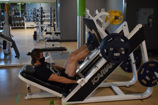 Fitness and health promotion student Vincent Bourdeau works out using the Fitness Zone's leg press machine. The Fitness Zone opened back up for community members Sept. 8.