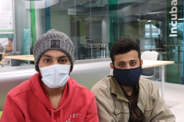 Electrical engineering technician students Gurpartap Singh (left) and his classmate Aditya Shah (right) studying together in the Dare District.