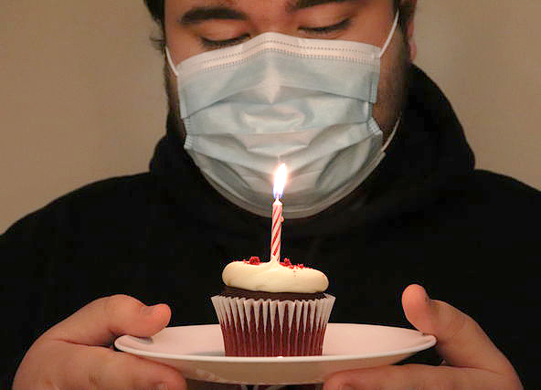 A student tries to blow out a candle for a pandemic birthday.