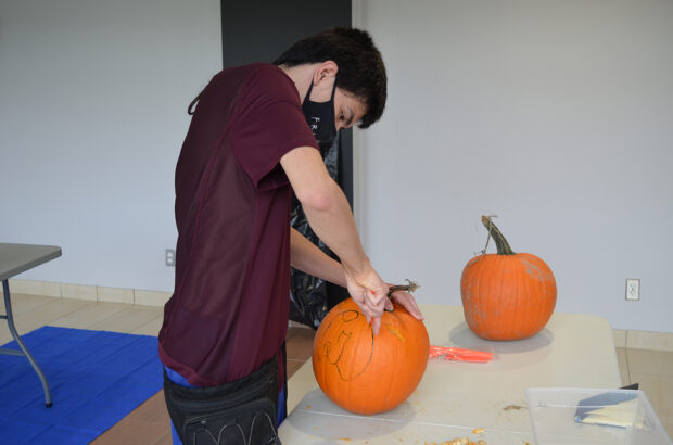 Whyte takes a less traditional approach to his pumpkin, as he begins to carve out a cat.