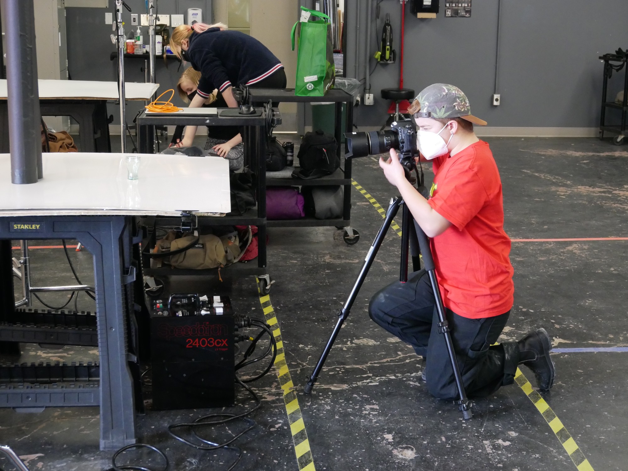 Rory Woodland, a first-year photography student, crouching to get the best shot for his glass assignment. Once a week, the first-year photography students get a chance to work in studio.