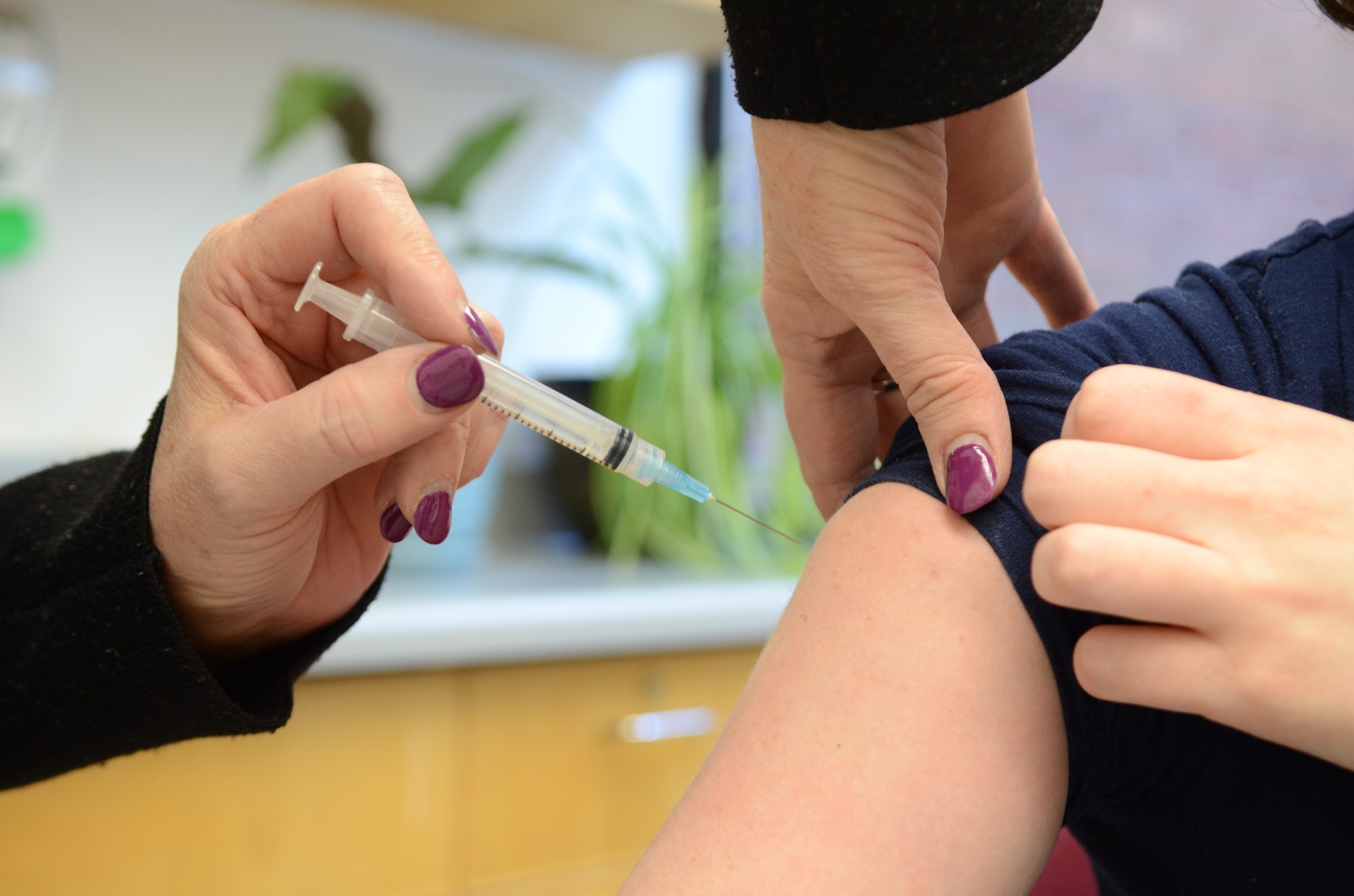 A Health Services nurse administering the flu shot vaccine at Algonquin College's Health Services.