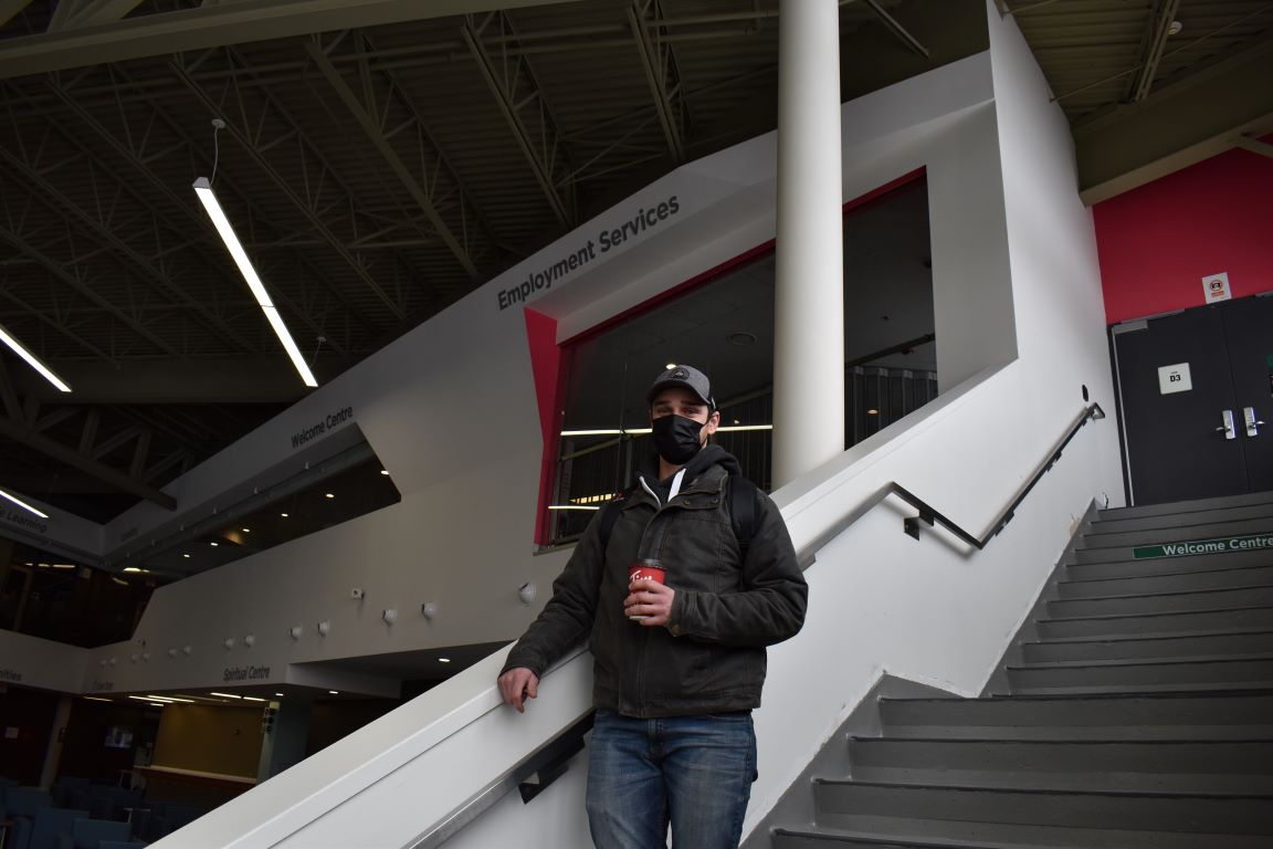Kyle McGuire, a second-year HVAC student, stands in front of the Employment Support Centre in the Student Commons.