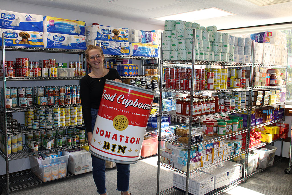 Food cupboard coordinator Julia McCann standing alongside the program's inventory.