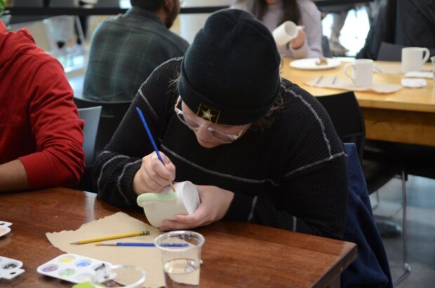 Students paint their own mugs at Pizza and Pottery night