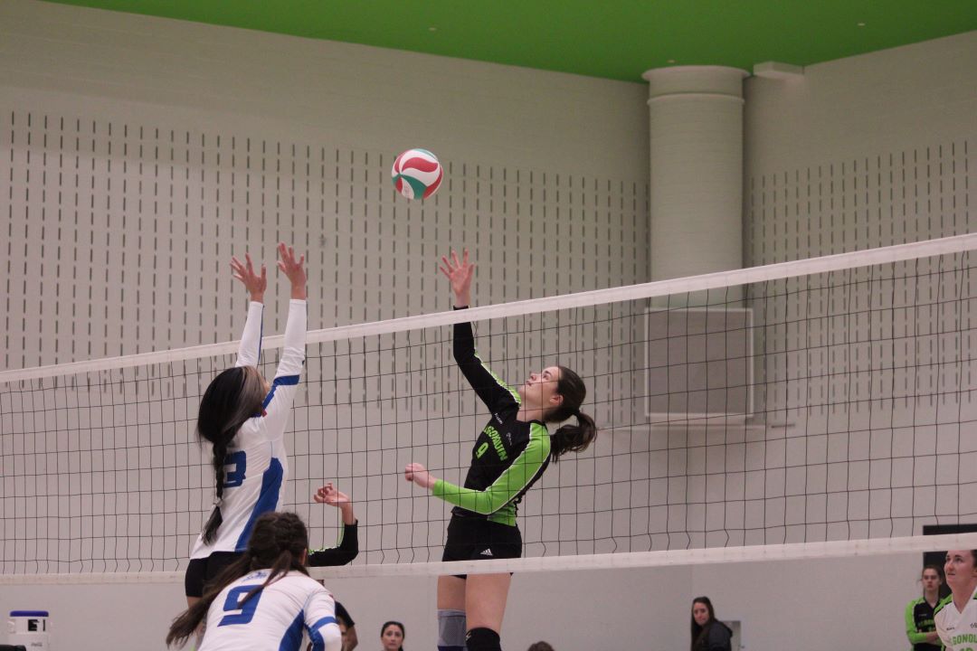 Kristina Renwick jumps to spike the ball against the George Brown Huskies.