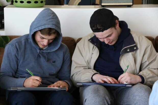 Dustin Villieneuve (left) and Alexandre Tremblay (right) working away on their postcards.