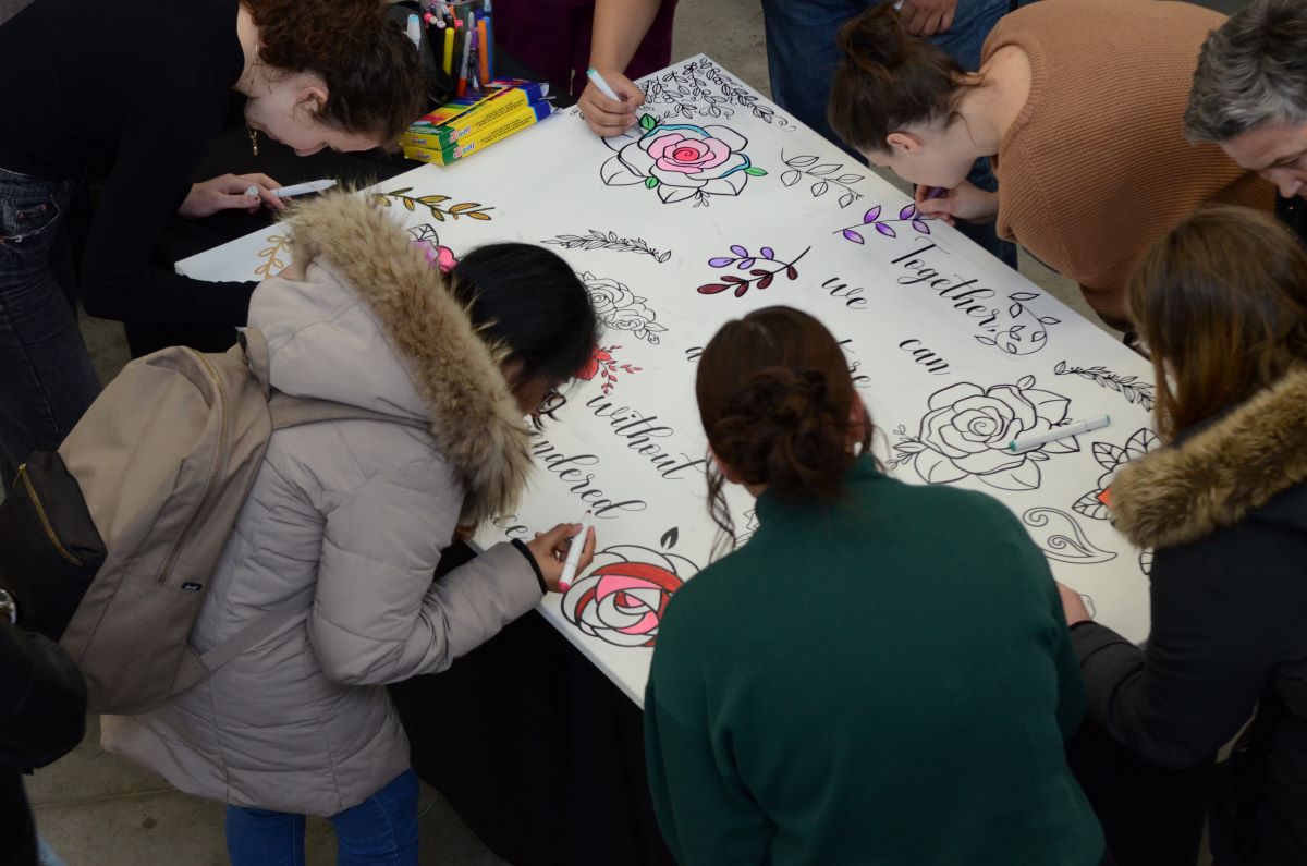 Students colour a collective art piece in memory of the victims of the École Polytechnique massacre.