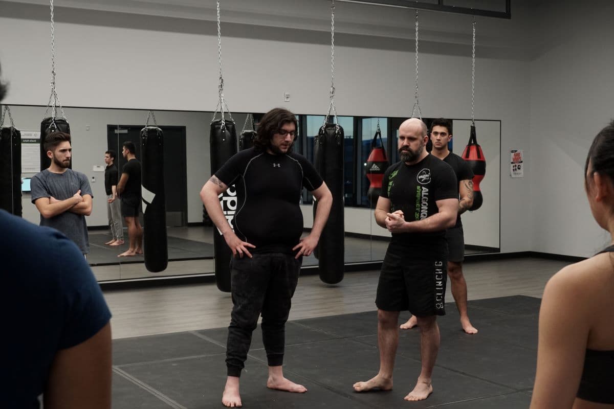 Terry Rea, MMA instructor (right), explains the fundamentals of MMA along with Raffi Yacoubian (center left).