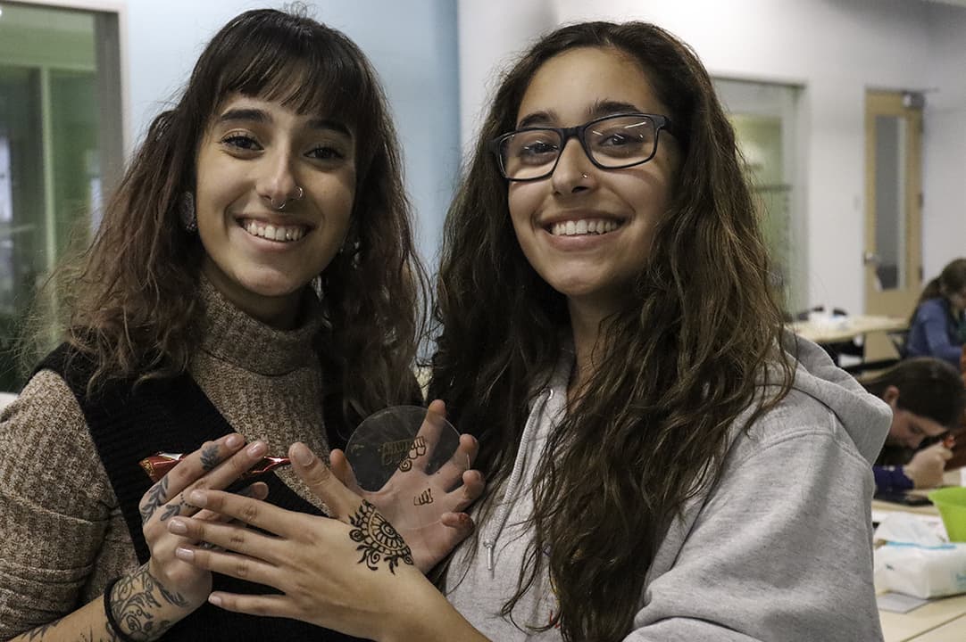 Henna artist Shelina Syed (left) with her twin sister Shameen Syed (right). Participants at the event were able to leave with a cone of henna to take home with them and practice creating designs.