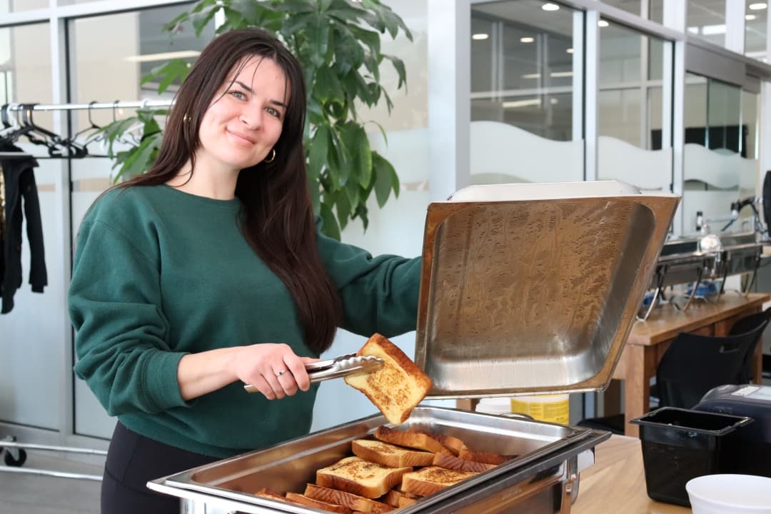 Samantha Therrien serves up French toast to students in the AC Hub on Feb. 6.