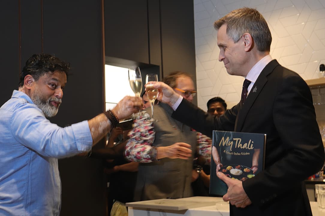 Mayor Mark Sutcliffe holds a signed copy Chef Joe Thottungal's second book, My Thali. They toasted in honor of the philanthropist chef who is a valuable community builder in Ottawa.