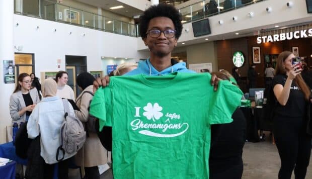 Malakai Sukree-Makori holding his winning prize of a Saint Patrick's day T-shirt after collecting five stamps with his friends