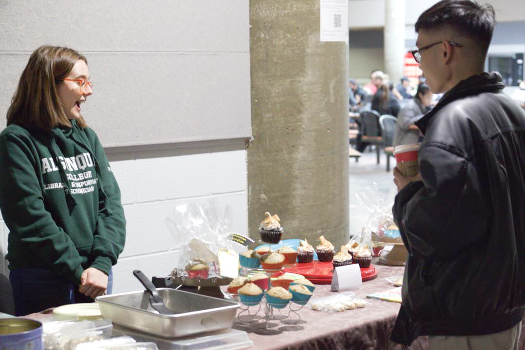 Jena Wren, a library and information technician student, selling sweets from the bake sale.