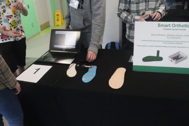 The Smart Foot Insole team's project table showing the data they collected on the laptop and the insole.