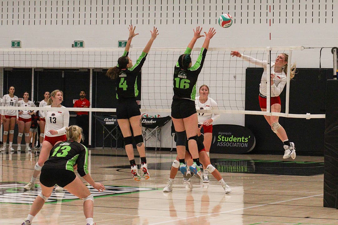 Chloe Rodgers (number 4) and Natasha Lauzon (number 16) attempt to block the ball from Canadore, with Gabrielle Paquette (number 13) ready to receive.