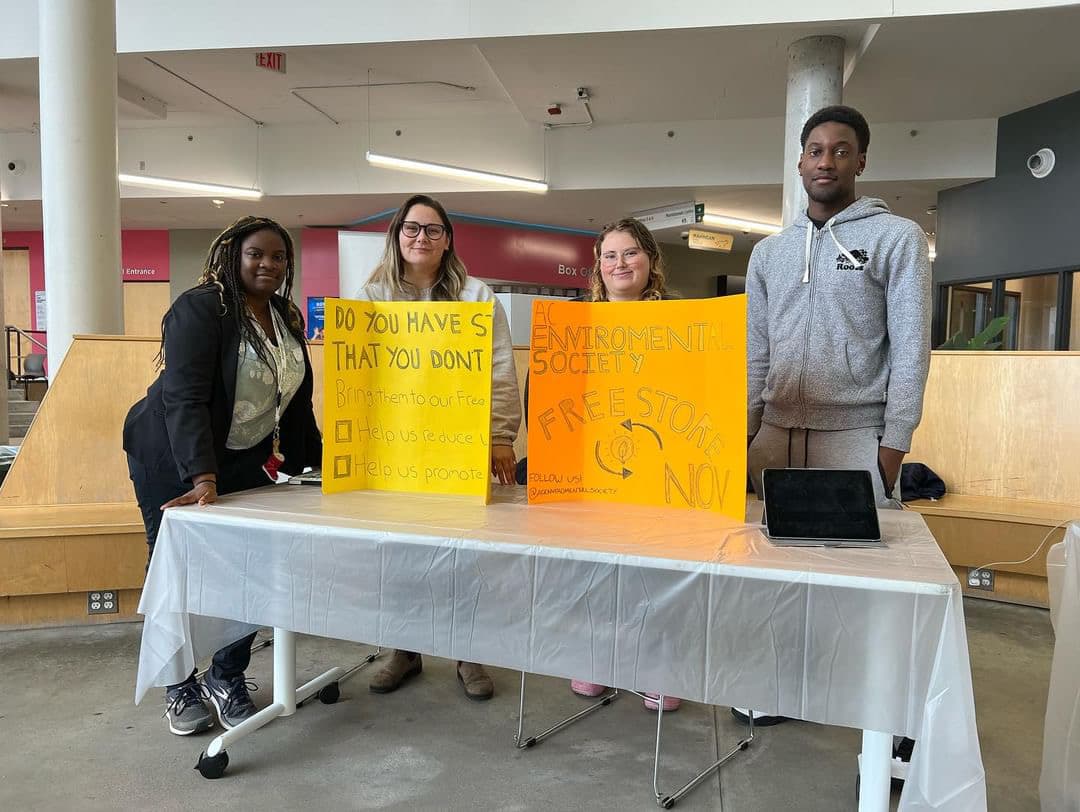 Karine Joseph, Sam Curtis, Stephanie Taylor and William Wafo pose behind the AC Environmental Society's promotional table at the Student Commons on Oct. 30, 2023.