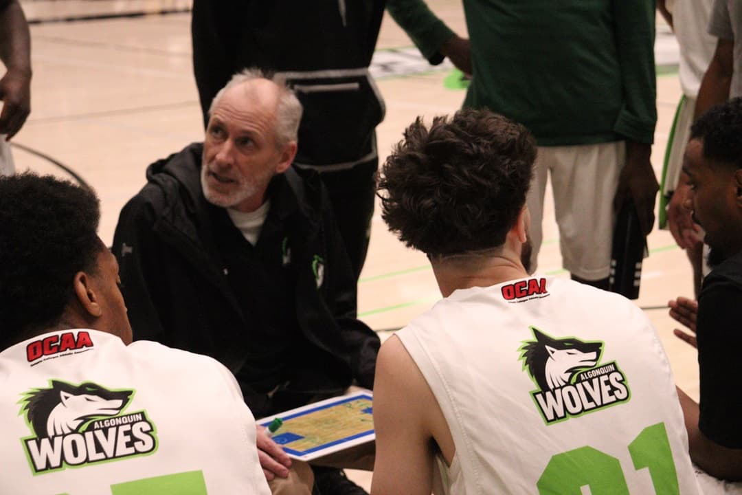 Head coach, Trevor Costello, gathered in a huddle with the roster before tip-off against the top-ranked George Brown Huskies.