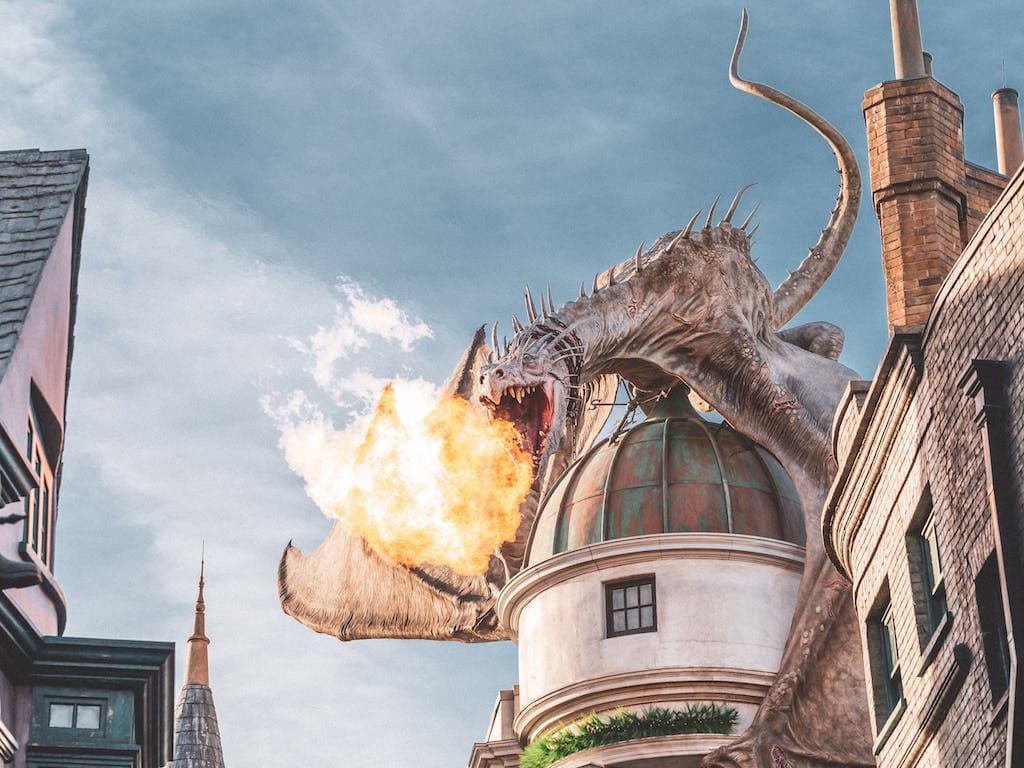 Dragon breathing fire on top of building.