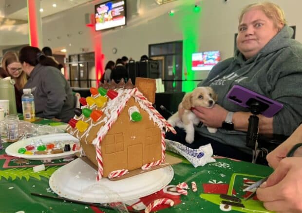 Developmental services student Jackie Leroux and her co-worker, Bao Bao make a gingerbread house while enjoying the happy energy.