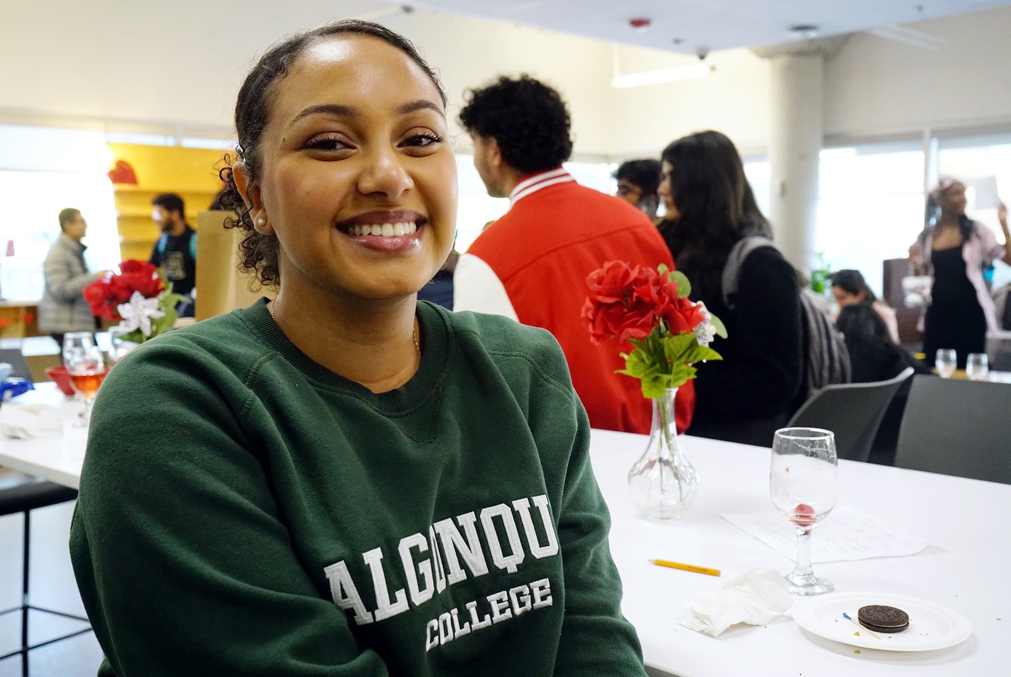 Delina Hailu, a student majoring in business administration at Algonquin College, enjoys snacks, drinks, and chatting with a new friend at the AC Hub.