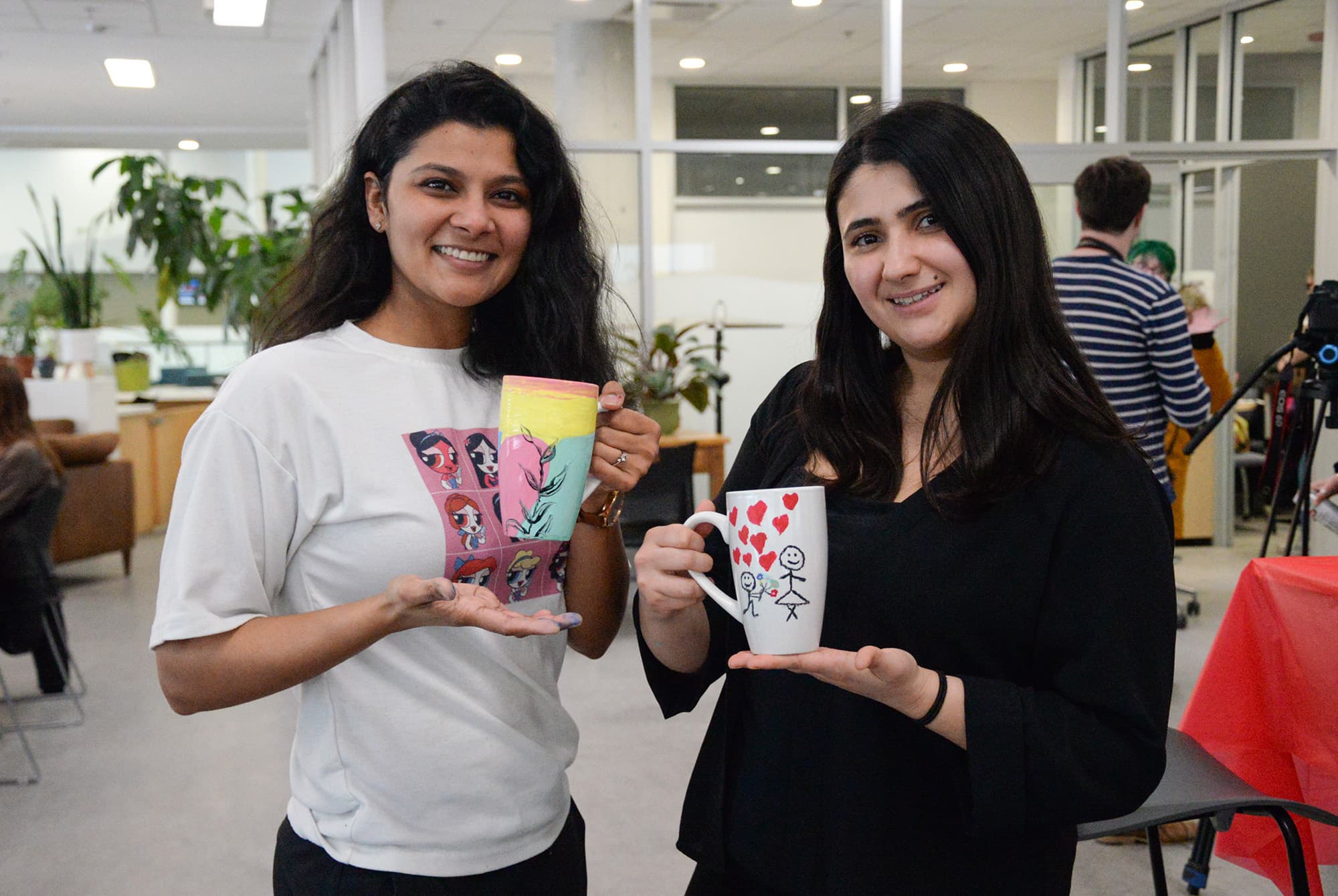 Gizem Akgul and Pragya Parmar show off their painted mugs.