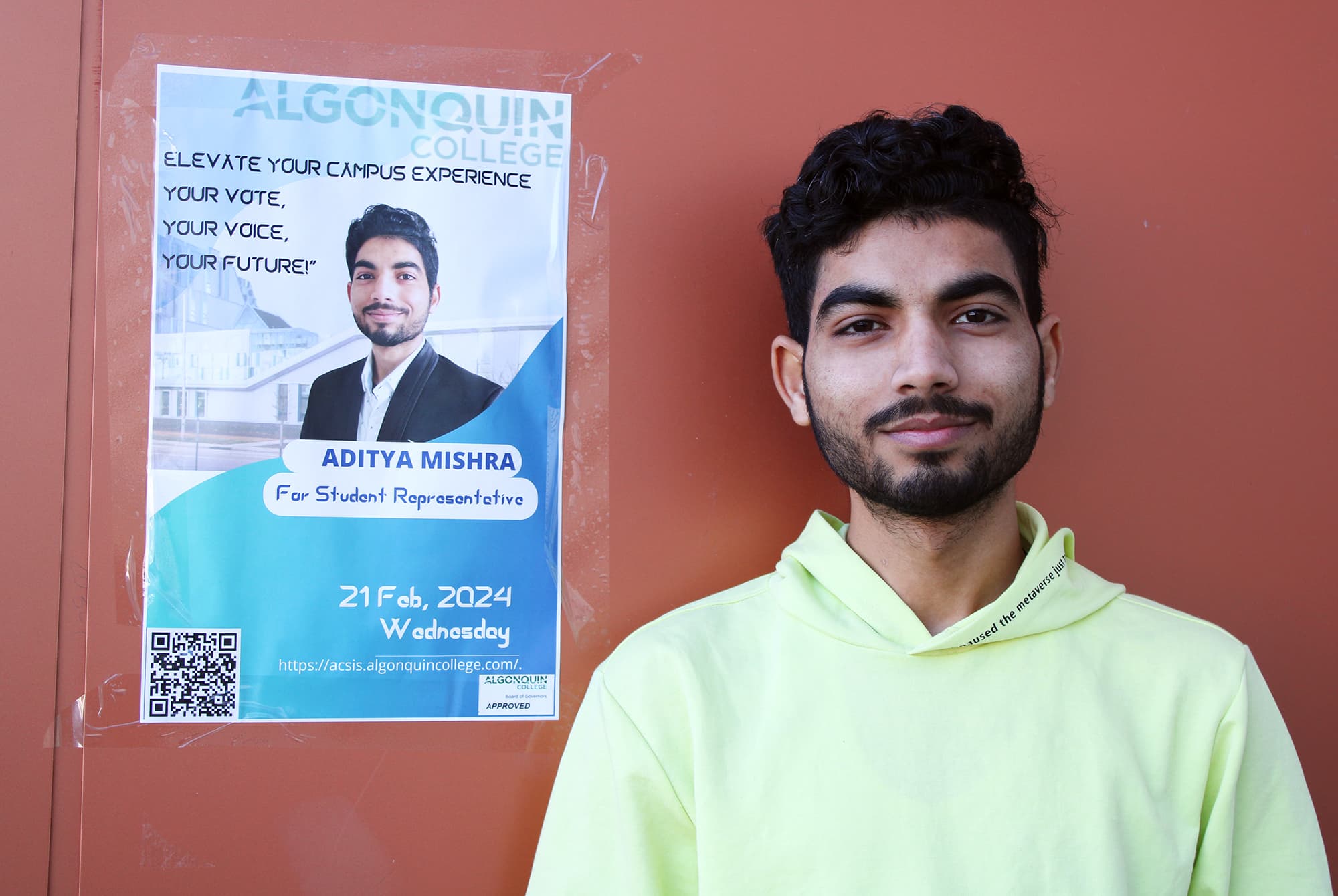 Aditya Mishra, Algonquin College's newly elected student representative, standing beside his poster outside of E-building on Feb. 24.