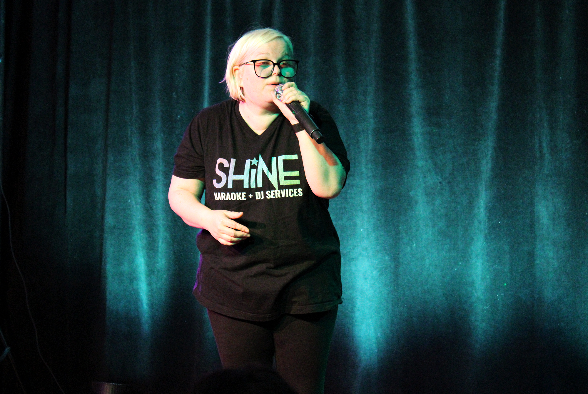 Christina Mackey, SHINE Karaoke owner, warms up the audience with some Tones and I.
