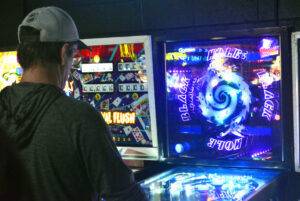 competitor playing the Black Hole pinball machine