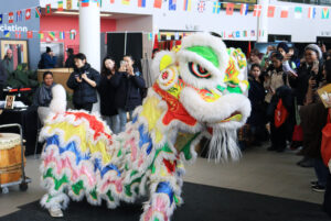 The Chinese Lion dance crew makes their entrance into the event, already drawing a large semi-circled crowd.
