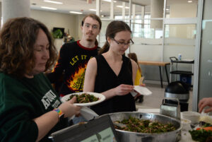 Pauline Thomson (left) and Miya Watson (right) getting a plate of kale slaw at the Adulting 101: National Nutrition Month event in the AC Hub. Photo credit: Isabella Disley