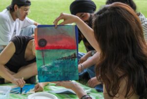 Ece Kaplan holds a nature scene she painted during the picnic