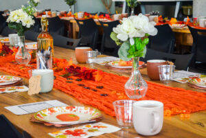 The table setting that includes fall themed decorations, Bingo and a take-home mug