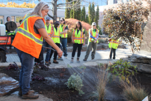 Angela Firman showing apprentices how to use watering equipment.