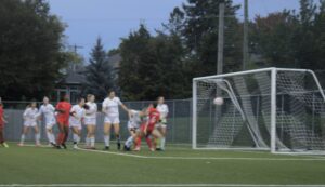 Players from both teams hold their breath as they await a potential goal.