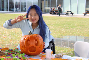 Yikun Liu displays her carved pumpkin at the Pumpkin Patch Party