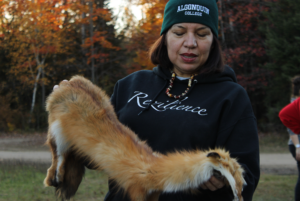 Anita Tenasco holding fox fur explaining the uses of the animal.