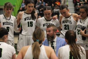 Coach Jaime McLean talks strategy with the Wolves women's basketball team before the final quarter of the game. The Wolves played against the St. Lawrence Surge on Nov. 8 at the Jack Doyle Athletics & Recreation Centre, located at Algonquin College's Ottawa campus.