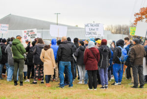 People gathered outside the Nepean Sportsplex on Sunday, holding signs calling for transparency.