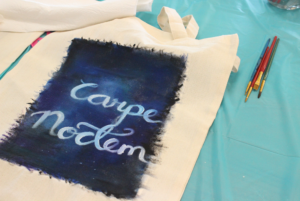 Carpe noctem” is a Latin phrase that means ‘seize the night’. Catura painted the night sky of her hometown and the misses of her friends on a tote bag.