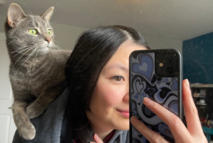 Smokey is sitting on my back and posing for a mirror selfie in my room. Photo credit: Isabella Disley